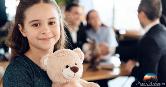 Daughter holding teddy bear, parents speaking to a lawyer in the background